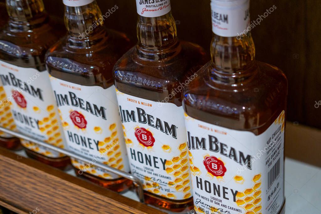 Row Jim Beam bourbon bottles on shelf, iconic label design alcoholic drink on shelf, iconic branding, sale in duty free, Madeira, Portugal - January 16, 2025