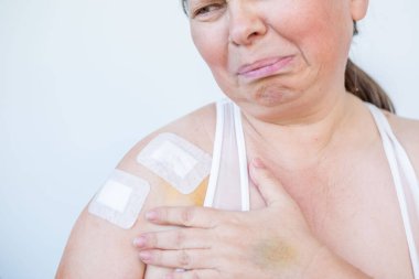 Doktor, cerrahi yarayı, kadın hastayı, omuz yaralanmasını, steril aletleri, iyileşme sürecini, klinik hijyeni, ameliyat sonrası bakımı, tıbbi profesyonel temizlik prosedürünü, 