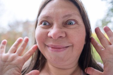 Dramatik bir portre. Şaşırmış bir kadın, şoke olmuş, gözleri açık, şişkin, inançsız ve beklenmedik haberler veren, inançsızlıkla ve şaşkınlıkla donmuş, duygusal bir yüzle bakıyor.