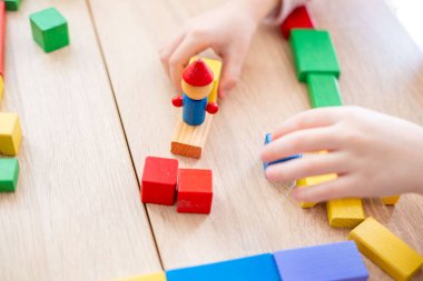 Tahta bloklar, mutlu, üzgün duygularla, anaokulu çocuğunun eli tahta bloklarla oynuyor, eğitici oyuncaklar, oyun zamanı, çeşitlilik ve dahil olma yoluyla duygusal gelişim 