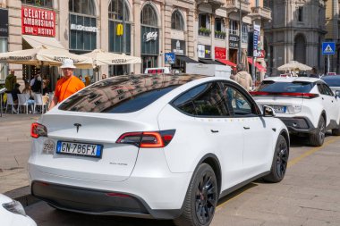 Şehir taksi durağı, Milano şehir merkezinde modern elektrik taksileri, Tesla ve Toyota İtalyan kafeteryası, şehir hayatı, çevre taşımacılığı, turizm, şehir mimarisi, Milano, İtalya - 21 Mayıs 2025 