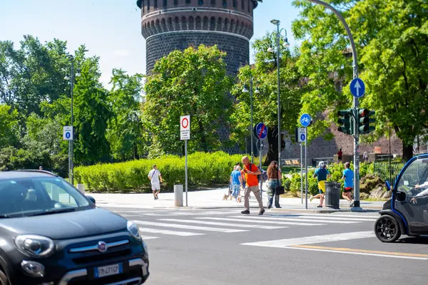 İnsanlar, turistler, yayalar, sokakta yürüyen sakinler, rahat Avrupa Milan şehri, modern araçlar, yol güvenliği, şehir merkezi Milan, İtalya - 21 Mayıs 2025