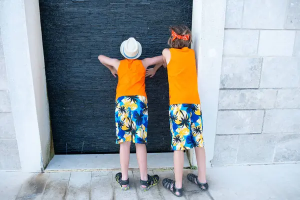 Çocuklar ellerini suya daldırıyor, genç turistler serin su yüzeyine dokunuyor, ellerini taşa bastırıyor, sıcak bir günde ferahlatıcı rahatlığın tadını çıkarıyor.