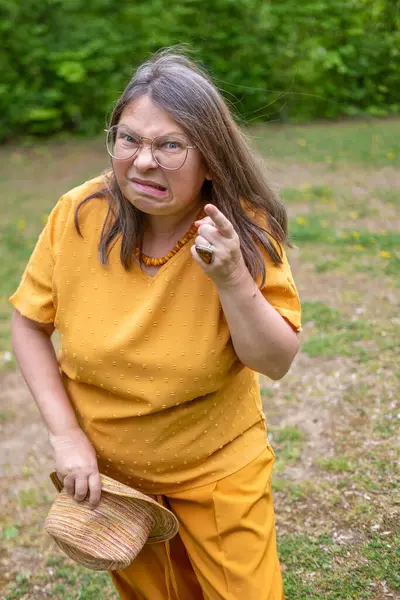 Yakın plan orta yaşlı kadın şok olmuş ve şaşkın bir ifadeyle, geniş gözler ve açık bir ağızla derin bir şaşkınlık, duygusal dramatik bir portre, şaşkınlık ve huşu sergiliyor. 