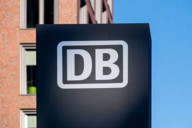 Mavi gökyüzüne karşı belirgin ikonik DB logosu olan modern bina, Deutsche Bahn şirketinin taşımacılık ve cam cephe bağlantısına karşı bağlantı, Frankfurt - 19 Ocak 2025