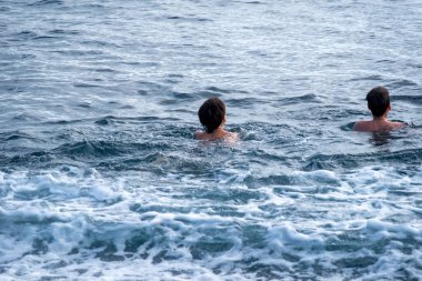 Denizde yüzen iki çocuk, mavi şişme salda sürükleniyorlar, açık denizde kaza yapıyorlar, şişme bot denizde daha da uzağa sürükleniyor, güçlü akıntıyla, su güvenliğiyle. 