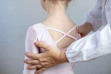 Genç balerinler geri döndü, skolyoz hastası küçük bir kız çocuğu 5 yaşında eğri büğrü duruyor, omurga deformasyonu eğri, ortopedik durum, tıbbi yardıma ihtiyacı var, pediatrik duruş 