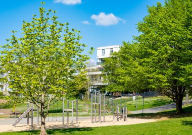 oyun ekipmanları, yeşil çimenler, açık hava oyunlarını ve çocukların eğlencesini sembolize eden doğal malzemeler ve açık hava oyun alanı