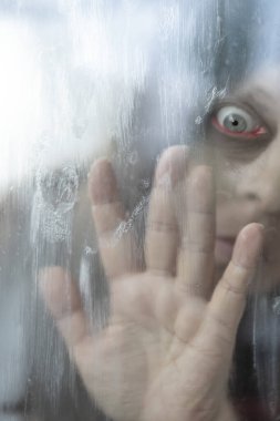 Umutsuz eller sisli camlara bastırılmış, bulanık camların arkasında bulanık bir kadın, elini uzatmış, izolasyon, zihinsel sıkıntı, sessiz yardım çağrısı, gerçeküstü korku sahnesi korkmuş yüz, iç savaş.