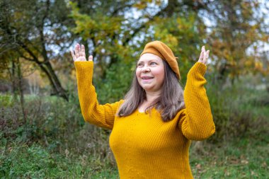 Yakın plan portresi son sınıf öğrencisi bir kadının aptal suratını çıkarması komik bir dil çıkarması komik surat buruşturması yaşlanan mizah kırışıklıkları sonbahar havası, komik yüzlü ve neşeli ruhlu yaşlı bir kadının doğal yakınlığı. 