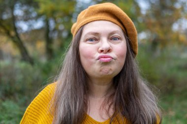 Yakın plan portresi son sınıf öğrencisi bir kadının aptal suratını çıkarması komik bir dil çıkarması komik surat buruşturması yaşlanan mizah kırışıklıkları sonbahar havası, komik yüzlü ve neşeli ruhlu yaşlı bir kadının doğal yakınlığı. 