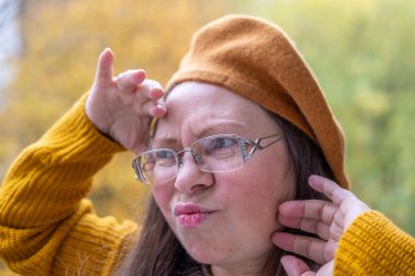 Yakın plan portresi son sınıf öğrencisi bir kadının aptal suratını çıkarması komik bir dil çıkarması komik surat buruşturması yaşlanan mizah kırışıklıkları sonbahar havası, komik yüzlü ve neşeli ruhlu yaşlı bir kadının doğal yakınlığı. 