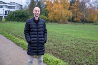 Doğada huzurlu bir anın tadını çıkaran bir adam sonbaharda günlük kıyafetlerini giyer, doğa düzeninde modaya uygun erkek modeller, kırsal alanda yürüyüş veya yürüyüş yapar, modern yaşam tarzı portreleri çizer. 