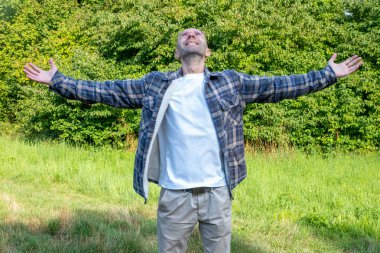 Doğada huzurlu bir anın tadını çıkaran bir adam sonbaharda günlük kıyafetlerini giyer, doğa düzeninde modaya uygun erkek modeller, kırsal alanda yürüyüş veya yürüyüş yapar, modern yaşam tarzı portreleri çizer. 