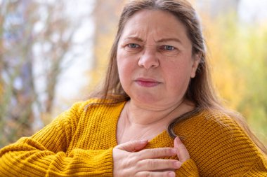 Şok olmuş, şaşırmış olgun bir kadın akıllı telefonunu tutar ve geniş gözleriyle duygusal tepki verir, şok içinde ekrana bakar. Beklenmedik haberlere duygusal tepki, virüs içeriği, beklenmedik online olay 