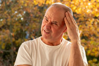 kederli ifadeli olgun bir adam, migren nöbeti, şiddetli migren ağrısı, baş ağrısı, acı dolu bir ifade, migren krizi, yakın plan yüzü,