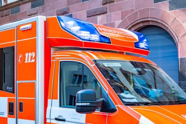 Alman itfaiye minibüsünde mavi ışıklar, şehir caddesinde park etmiş acil ambulans, itfaiye, kırmızı kurtarma aracı, tıbbi müdahale, Frankfurt, Almanya - 26 Temmuz 2025
