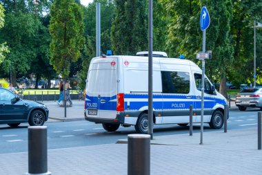 Alman polis minibüsü şehir caddesinde ilerliyor, mavi ve beyaz POLIZEI aracı, şehir güvenlik devriyesi, kamu güvenliği, kolluk kuvveti, Frankfurt, Almanya - 26 Temmuz 2025