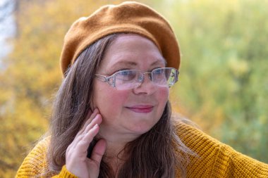 Sonbaharda sıcak bereyle güz mevsiminin tadını çıkaran, altın sonbaharda rahat giysiler giyen, doğal güzellik ve neşe, kendine bakım, sağlıklı pozitif yaşlanma