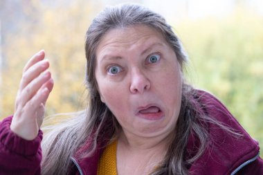 Şokta olan orta yaşlı bir kadın, ağzı açık ve gözleri açık, saf duygu sürprizi ve inançsız beklenmedik haberleri yakalıyor, olgun bir kadın şaşkınlık ve şokla tepki veriyor. Duygusal Portre