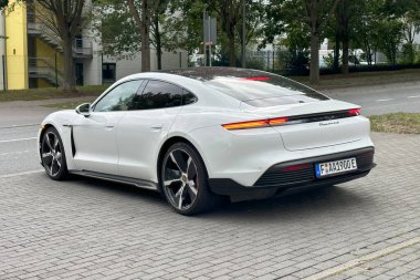 Üst düzey elektrikli Porsche Taycan aracı, modern beyaz spor sedan, modern otomotiv, yüksek performanslı hareketlilik, Frankfurt, Almanya 'da lüks sürdürülebilir ulaşım - 11 Ağustos 2025