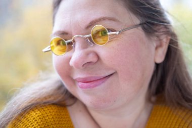 Kuşkucu olgun kadın açık havada, kadın yüzü hayal kırıklığını, şüpheciliği ve duygusal acıyı gösteriyor. Yakın plan, hayal kırıklığını ve şüpheyi gergin bir pozla ifade eden kadın modeli. 