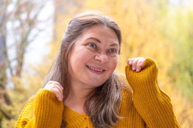 Kuşkucu olgun kadın açık havada, kadın yüzü hayal kırıklığını, şüpheciliği ve duygusal acıyı gösteriyor. Yakın plan, hayal kırıklığını ve şüpheyi gergin bir pozla ifade eden kadın modeli. 