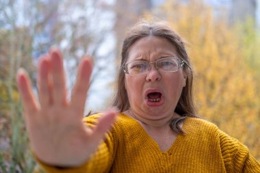 Kuşkucu olgun kadın açık havada, kadın yüzü hayal kırıklığını, şüpheciliği ve duygusal acıyı gösteriyor. Yakın plan, hayal kırıklığını ve şüpheyi gergin bir pozla ifade eden kadın modeli. 