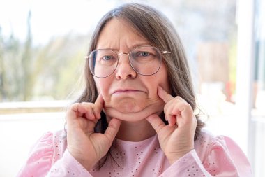 Kızgın Agresif Stresli Kadın 50 'li yaşlarda, yoğun hayal kırıklığı, çatışma, stres, modern yaşam baskısı, zihinsel sağlık sorunları, işyeri hüsranı, üzgün yüz ifadesi yaşayan görsel kişi. 