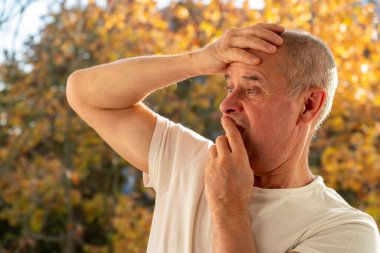 Mutlu, beyaz, olgun bir adam, 60-65 yaşlarında, yeşil doğal arka planda gülümseyen, iyi ruh hali, yaşla ilgili değişiklikler, insan sağlığı kavramı, yetişkinlikte iyimserlik. 