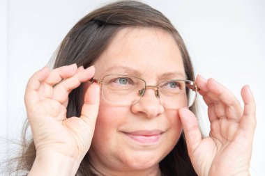 Şaşırmış, orta yaşlı, açık havada uzun saçlı bir kadın, şok olmuş bir yetişkin portresi, stres, hayat sorunları, yüz ifadesi. Şok, şaşkınlık ve beklenmedik duygular konsepti 