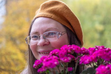 Şaşırmış, orta yaşlı, açık havada uzun saçlı bir kadın, şok olmuş bir yetişkin portresi, stres, hayat sorunları, yüz ifadesi. Şok, şaşkınlık ve beklenmedik duygular konsepti 