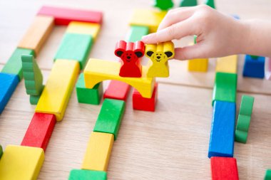 çocuk, kız 5 yaşında eğlenceli oyun masasında renkli tahta figürler, oyuncaklar ve bloklar, erken eğitim ve yaratıcı oyun, iyi motor beceriler, yaratıcı oyun zamanı