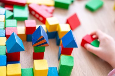 çocuk, kız 5 yaşında eğlenceli oyun masasında renkli tahta figürler, oyuncaklar ve bloklar, erken eğitim ve yaratıcı oyun, iyi motor beceriler, yaratıcı oyun zamanı