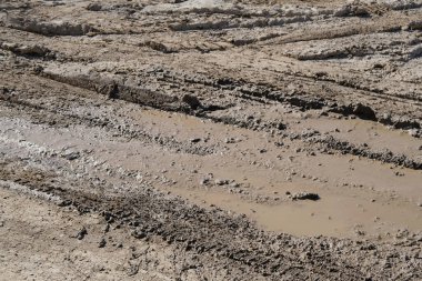 Şiddetli yağmur ve eriyen kardan sonra çamurlu yollarda lastik izleri, ıslak, çamurlu çamurlu arazide lastik izleri, off-road ortamının zorlukları.