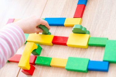 çocuk, kız 5 yaşında eğlenceli oyun masasında renkli tahta figürler, oyuncaklar ve bloklar, erken eğitim ve yaratıcı oyun, iyi motor beceriler, yaratıcı oyun zamanı