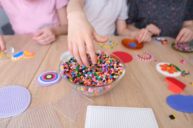 Çocuk ellerine yakın çekim yapmak, perler boncuk desenleri yaratmak, termomomomomozik tekniği, boncuk şekilleri, boncuk sanatı, ince motor becerilerin kavramsal gelişimi, termomomoelektrik fikirler kullanarak el sanatları yapmak.