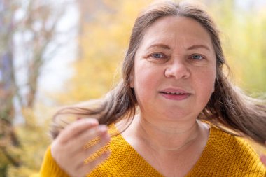 50 'li yaşlardaki kadınlar vitamin eksikliği ve yaşlanma nedeniyle kırılgan ve hasarlı saçları, incelmeyi ve kuruluğu inceliyor. Olgun kadınlarda trichology yardımı, sağlık hizmetleri için yaygın olan gerçekçi tasvir saç sorunları.