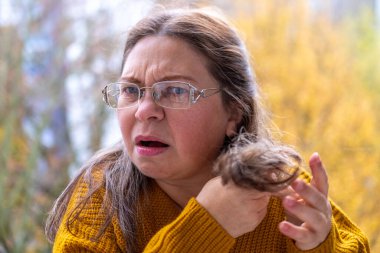 50 'li yaşlardaki kadınlar vitamin eksikliği ve yaşlanma nedeniyle kırılgan ve hasarlı saçları, incelmeyi ve kuruluğu inceliyor. Olgun kadınlarda trichology yardımı, sağlık hizmetleri için yaygın olan gerçekçi tasvir saç sorunları.