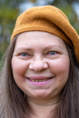 Kendine güvenen, orta yaşlı, 55 yaşında, uzun saçlı, doğal güzelliği kucaklayan, kendine güvenen, kendine güvenen, iç huzuru ve güveni olan, zamansız kadınsı bir kadın. 