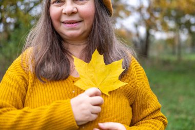 Kendine güvenen, orta yaşlı, 55 yaşında, uzun saçlı, doğal güzelliği kucaklayan, kendine güvenen, kendine güvenen, iç huzuru ve güveni olan, zamansız kadınsı bir kadın. 