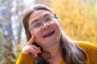 Kendine güvenen, orta yaşlı, 55 yaşında, uzun saçlı, doğal güzelliği kucaklayan, kendine güvenen, kendine güvenen, iç huzuru ve güveni olan, zamansız kadınsı bir kadın. 