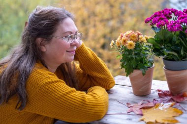 Kendine güvenen, orta yaşlı, 55 yaşında, uzun saçlı, doğal güzelliği kucaklayan, kendine güvenen, kendine güvenen, iç huzuru ve güveni olan, zamansız kadınsı bir kadın. 