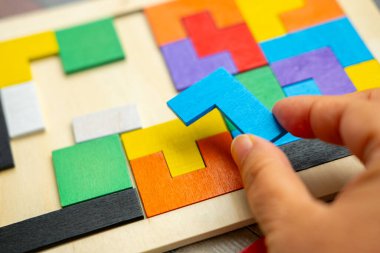 Çocuğun parmakları trafoları manipülatörle hareket ettirir, tasarımcı parçalarından monte edilir, bokeh ile yeşil arka plan, iyi motor becerilerin geliştirilmesi konsepti, yaratıcılık, çocuk eğlencesi 