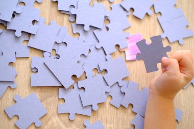 Çocuğun parmakları trafoları manipülatörle hareket ettirir, tasarımcı parçalarından monte edilir, bokeh ile yeşil arka plan, iyi motor becerilerin geliştirilmesi konsepti, yaratıcılık, çocuk eğlencesi 