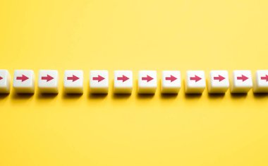 Ok sırasına dizilmiş bloklar. Bir yönde hareket var. Sıralı ok zinciri. Rotayı ayarlayın, yolunuzu ayarlayın. Adım adım ilerlemeye devam ediyoruz. Motivasyon, kendini geliştirme. Stratejik planlama.