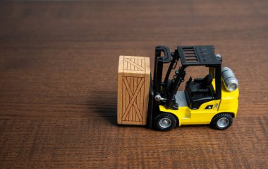 Bir forklift, ahşap bir sandık taşıyor. Ulaşım hizmetleri ticareti. Dışarıya aktar. Depoda. Teslimatlar takip ediliyor. Nakliye. Paketleme ve ulaşım lojistiği.