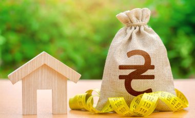 Ev heykelciği ve Ukraynalı Hryvnia para çantası. Mülk değeri. Bina bakımı. İpotek kredisi hesaplaması. Ev hizmetlerinin maliyeti, kamu hizmetleri. Enerji verimliliği. Gayrimenkul değerlendirmesi.