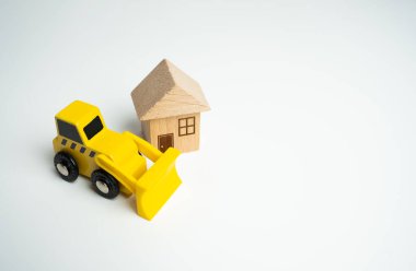 Buldozer ve ev. Yıkım hizmetleri, arazi döşeme ve inşaat için diğer arazi işleri. Özel mülke izinsiz giriş. Yasadışı binalar. Bina kurallarının ihlali. Konut yenileme.