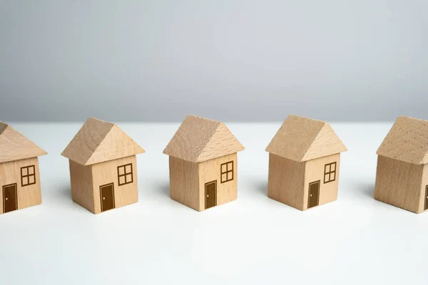 木製のおもちゃの家の行に立っている 最も適切な住宅オプションを見つける 不動産市場で提供しています 住宅ローン 住宅の評価 不動産業者のサービス — ストック写真